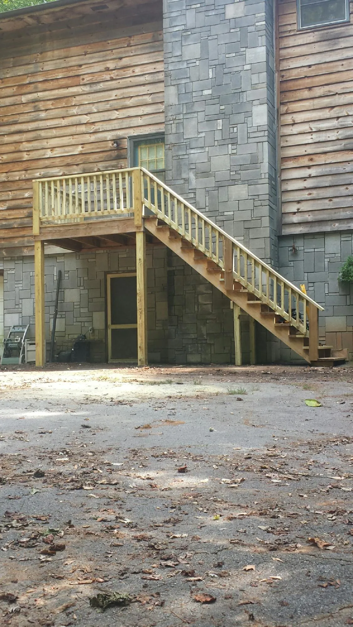 New pressure treated deck and stair landing on a log home in Madison